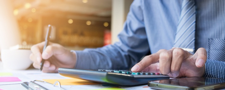 un homme en chemise calculant sur une calculatrice