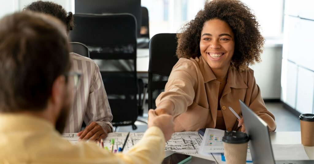 une personne serrant la main à une autre en entreprise