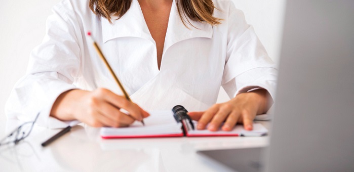 une femme écrivant sur un cahier