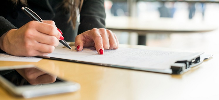 une femme écrivant sur une feuille