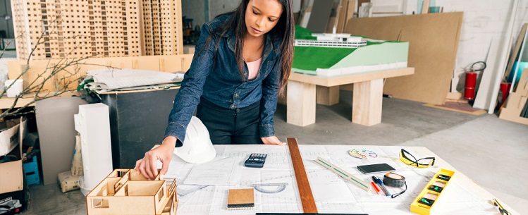 une femme devant des plans de construction