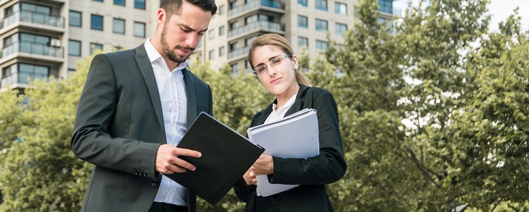 deux agents immobilier devant des immeubles