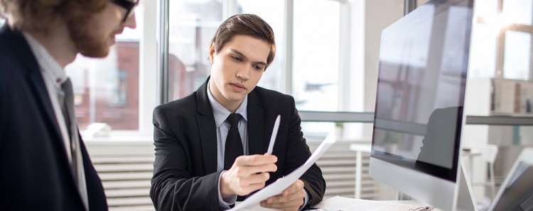 une jeune homme en costume cravatte travaillant a son bureau