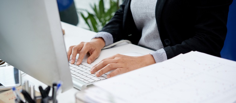 une femme écrivant sur un clavier d'ordinateur