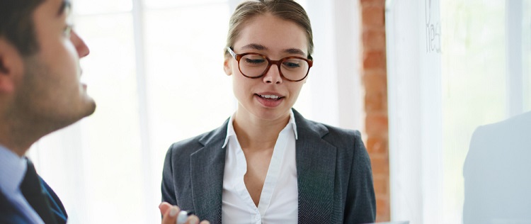 une jeune femme à lunette parlant à un homme en costume