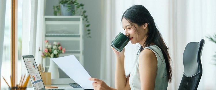 une femme buvant un café et regardant des chiffres