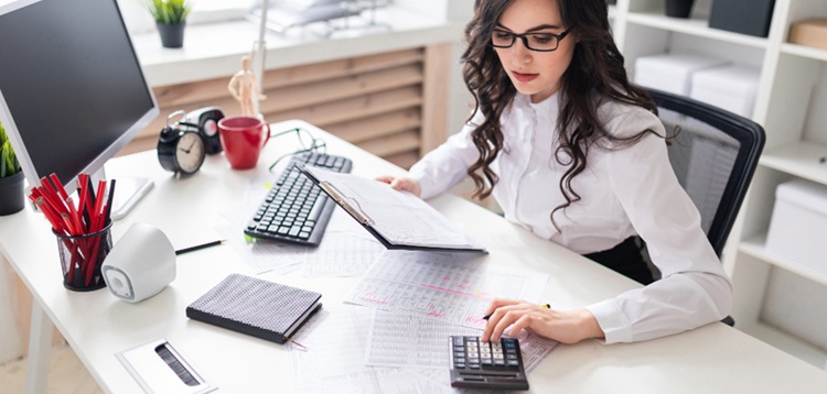 une femme brune travaillant des chiffres à son bureau