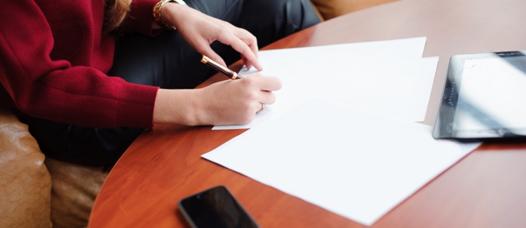 une femme rédigeant une lettre sur une feuille blanche