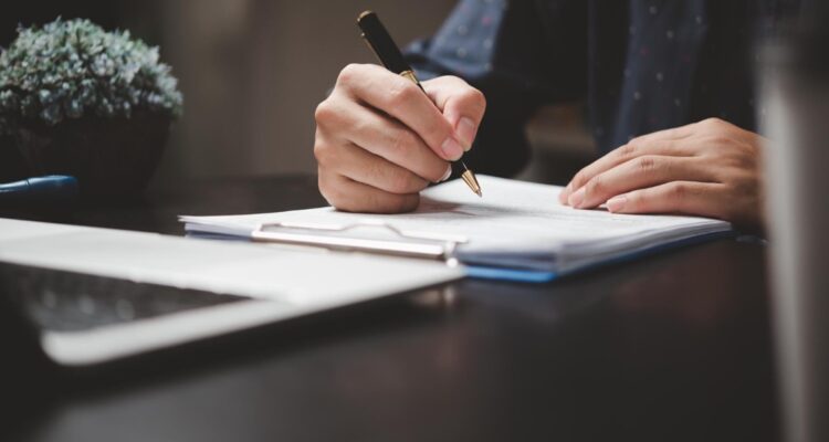 un homme rédigeant une lettre de motivation à son bureau