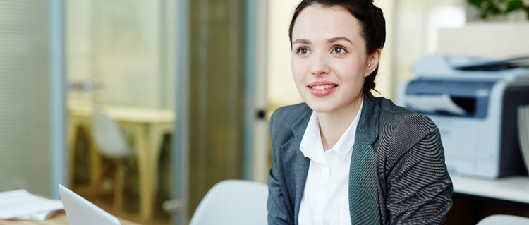 une jeune assistante de direction souriante à son bureau