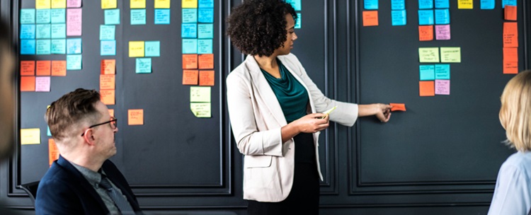 une femme assemblant des post-it pour une gestion de projet