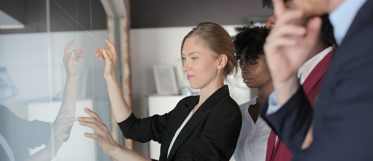 un groupe de personnes travaillant debout devant un tableau