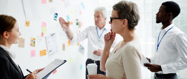 des peronnes devant un tableau de gestion de projet