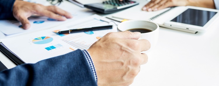 une personne à son bureau tenant un tasse de café