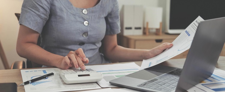 une femme tapant sur une calculatrice