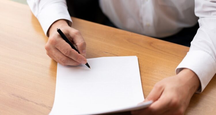 une personne rédigeant une lettre de motivation pour un BTS gestion de la PME