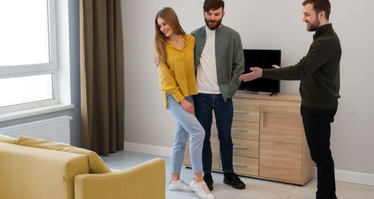 une agent immobilier faisant visiter un appartement à un jeune couple