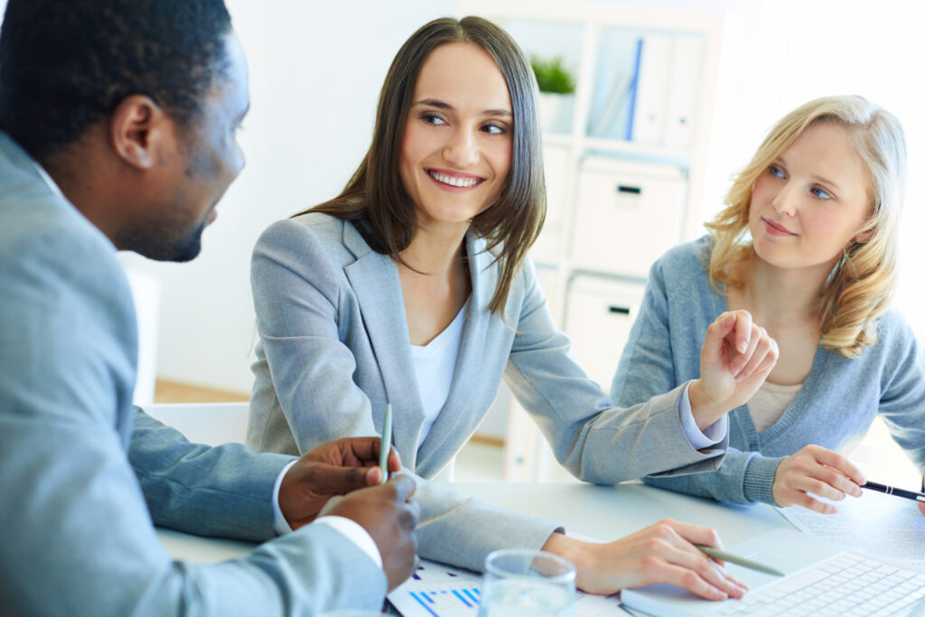 trois personnes discutant au bureau