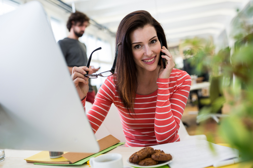 une jeune femme au téléphone à son bureau