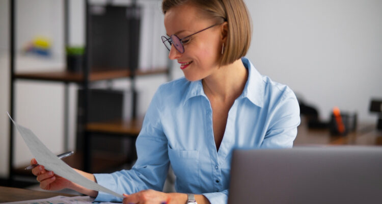 une femme souriante travaillant devant son ordinateur