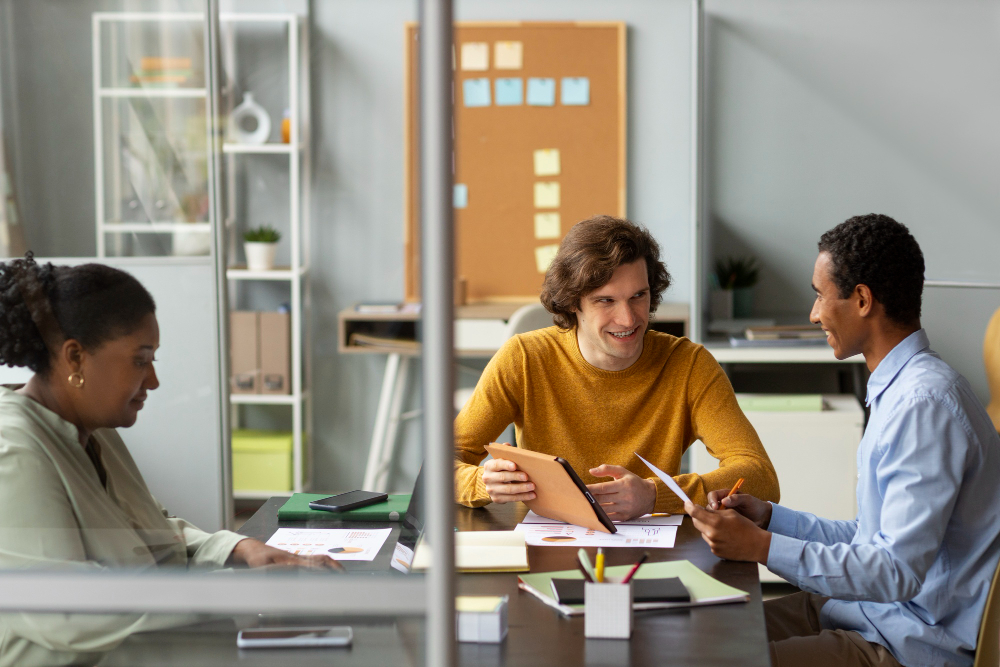 trois personnes travaillant sur un bureau