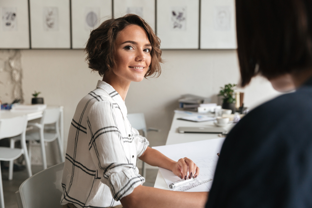 une chargé d'accueil souriante à son bureau