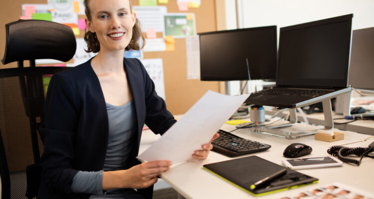 une chargé d'accueil souriante à son bureau