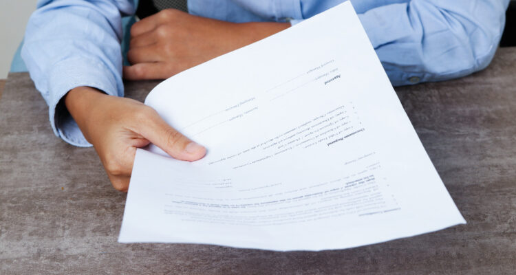 une personne tenant une lettre de motivation