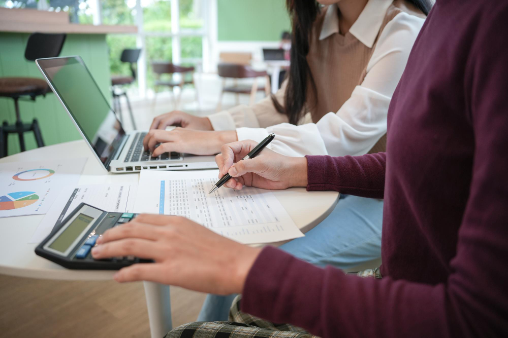 deux femmes travaillant sur un ordinateur portable et des chiffres comptable