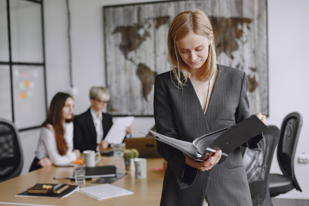une juriste en entreprise consultant des documents debout dans un bureau