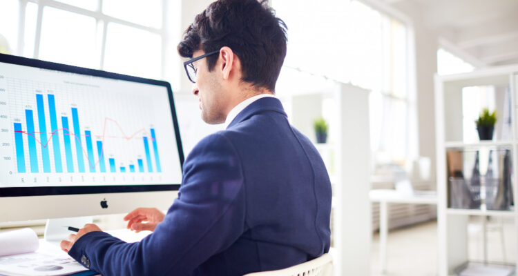 un analyste financier devant son pc