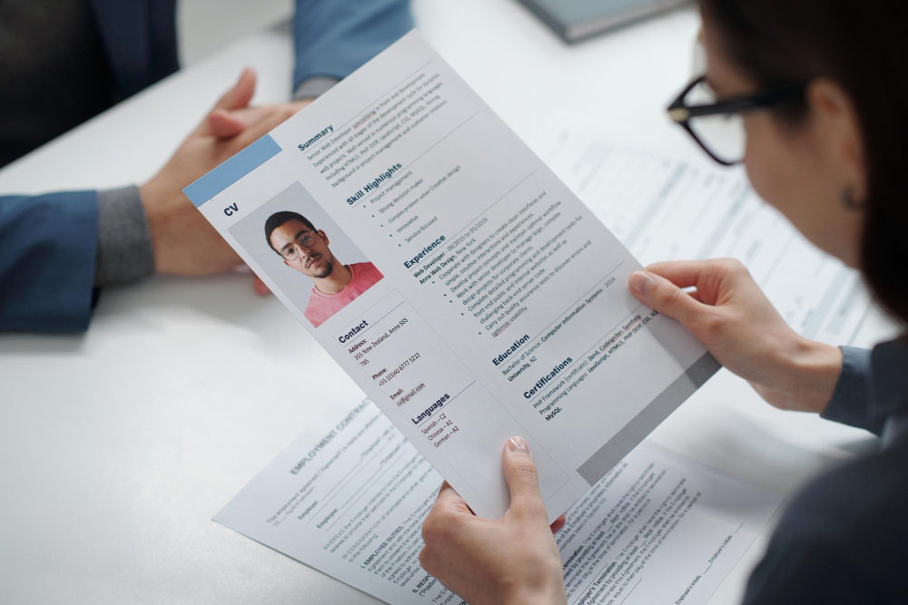 une femme tenant un cv dans ses mains